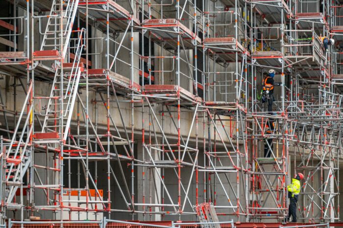 a man standing on a scaffold in front of a building